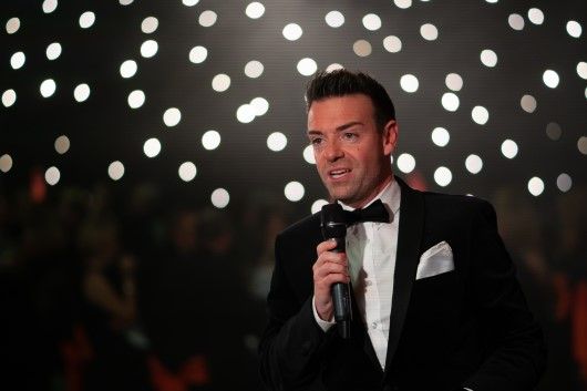 Des Clarke hosting the Winter Dinner Dance in front of a star cloth.