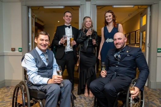 Five guests, including two in wheelchairs, pose for a picture at the Winter Dinner Dance 2021