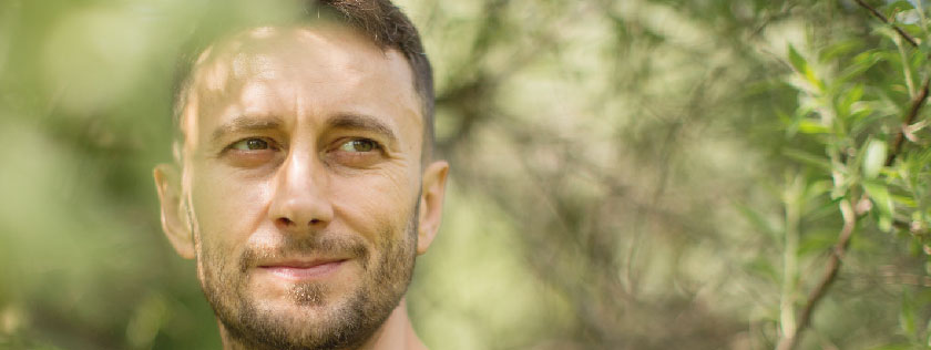 Man in woods looking thoughtful