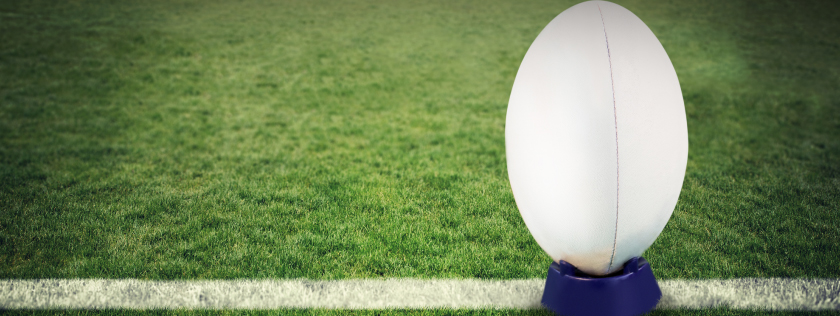 Rugby ball ready to kick on pitch