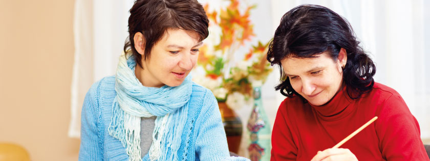 Two ladies at table painting