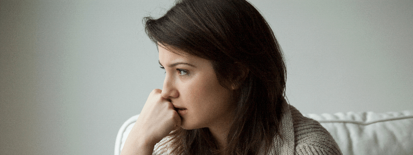 Worried woman sitting on couch
