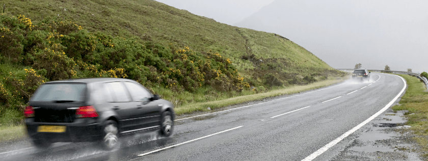 Car driving in the rain on country road