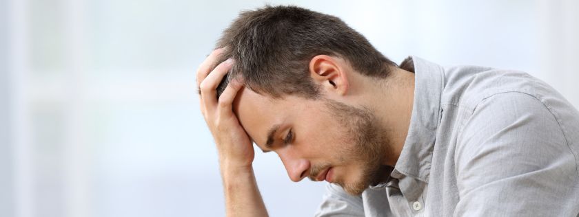 Man with head in hand looking sad