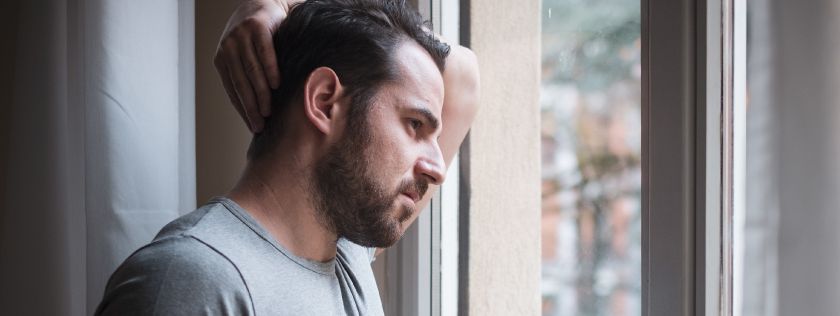 Man looking out window