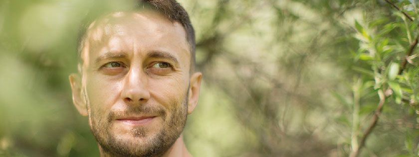 Man in woods looking thoughtful