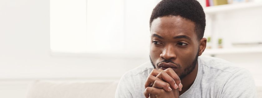 Man sitting on couch looking concerned