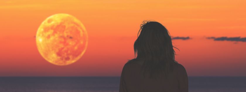 woman looking out to sea at sunset