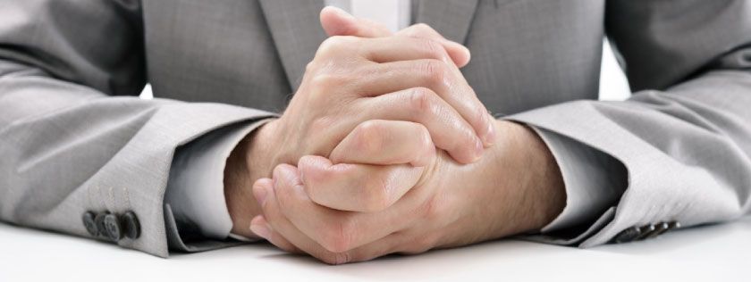 Man in suit with hands on table