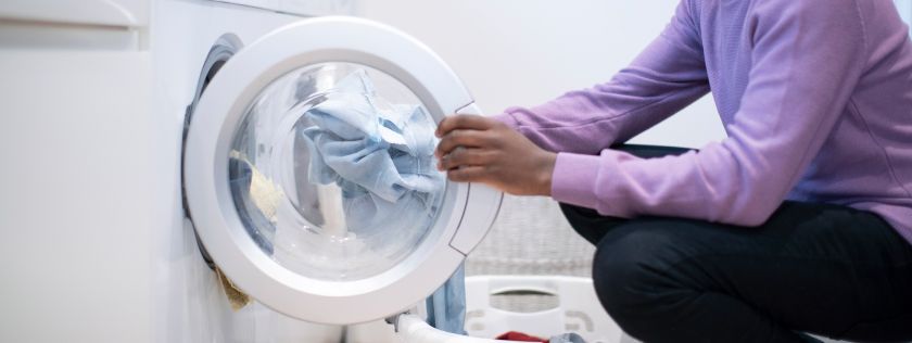 Man dloading tumble dryer