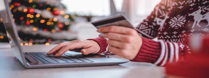 Woman doing christmas shopping online at laptop