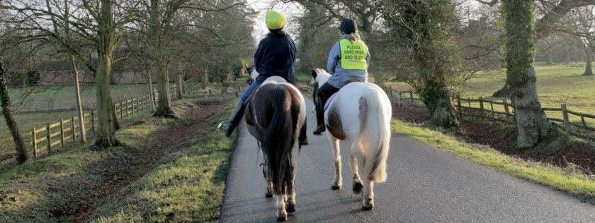 Two riders going along a road