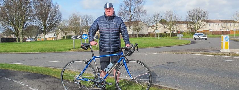 David with his bike standing where he was hit by a driver at a roundabout