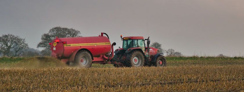 Tractor and muck spreader on farm
