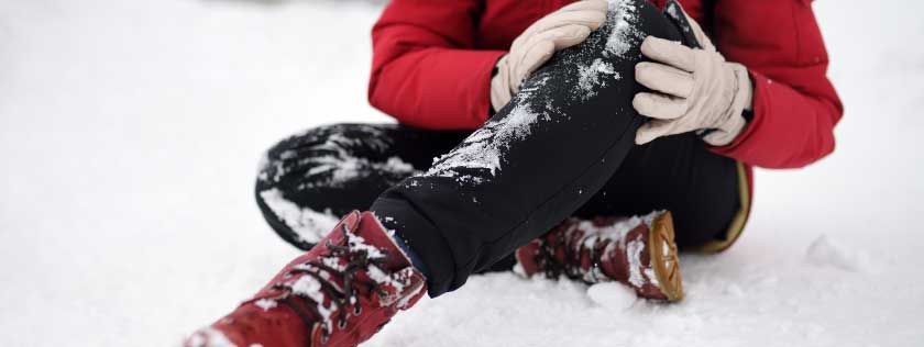 Woman holding knee having slipped on ice