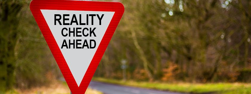 Road sign with reality check ahead written on it