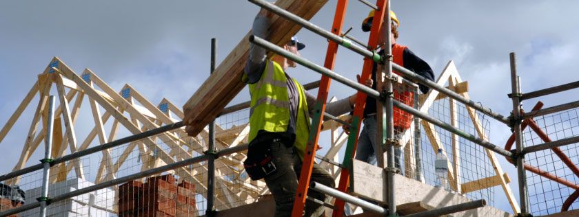 Two workers up scaffolding on construction site