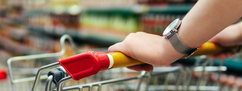 Shopping in supermarket pushing trolley