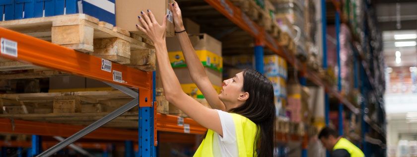 Warehouse worker getting a package from shelf