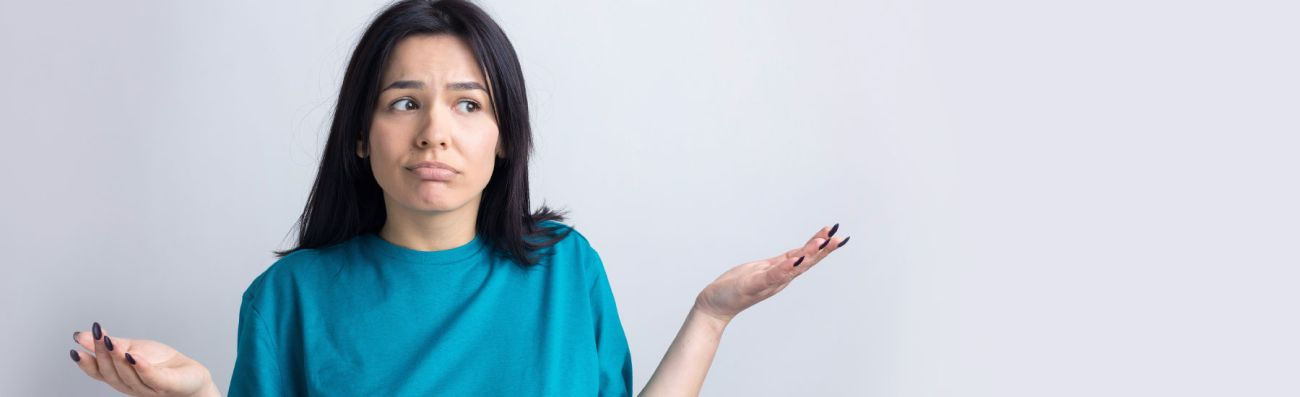 Woman looking confused with shrug and hands raised