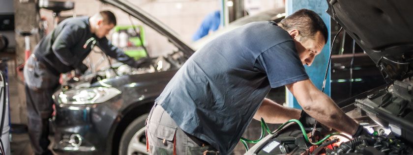 Mechanics working on cars in a garage