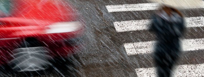 Pedestrian crossing road in rain