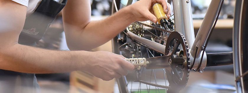 Bike mechanic working on chain