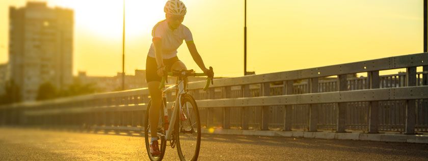 Woman cycling along road