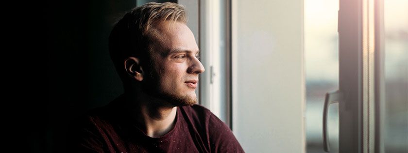 Man looking out window