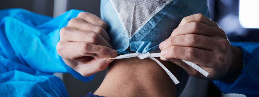 Surgeon tying mask before surgery