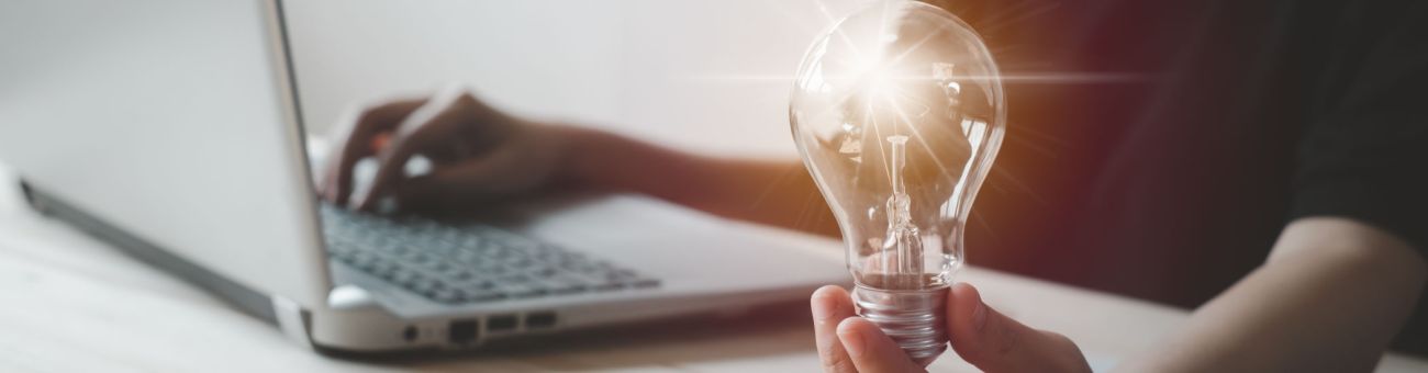 Woman on laptop with lightbulb