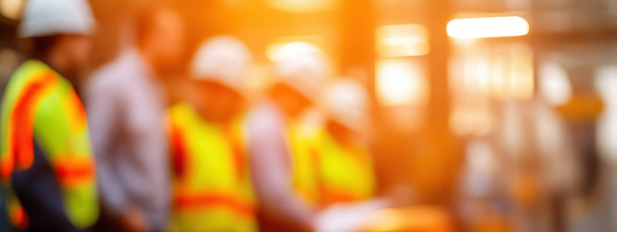 Workmen wearing high-vis jackets and hard hats over their uniform