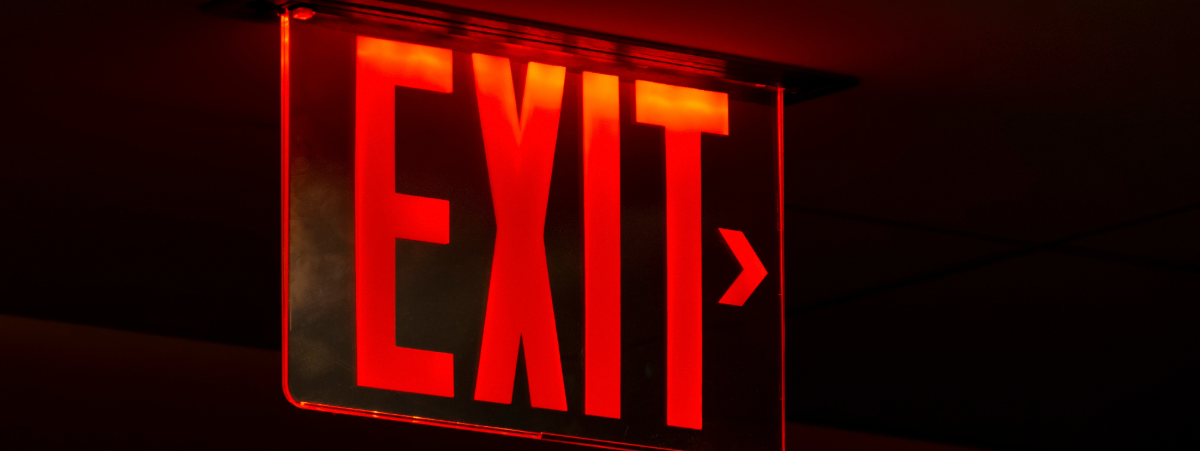 Red exit sign on a dark background
