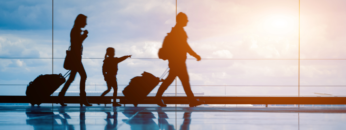Three people walking with suitcases in an airport