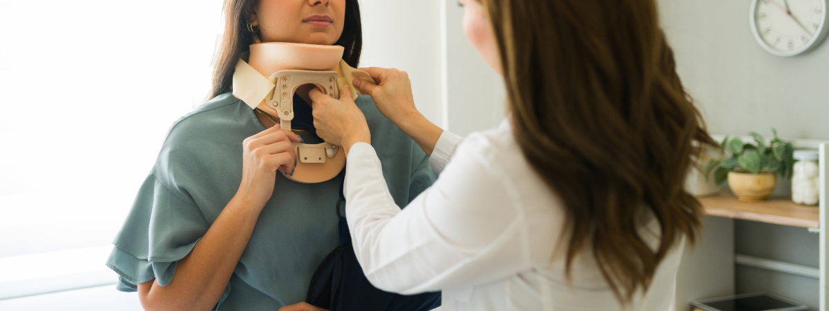 A health professional securing a neck brace on a woman.
