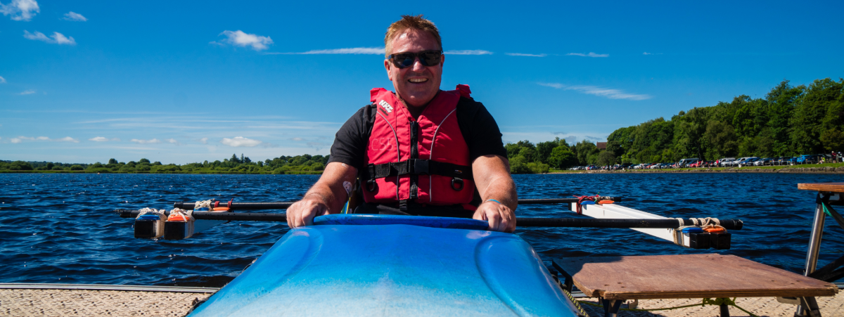 A male wheelchair user pictures in an adaptable kayak