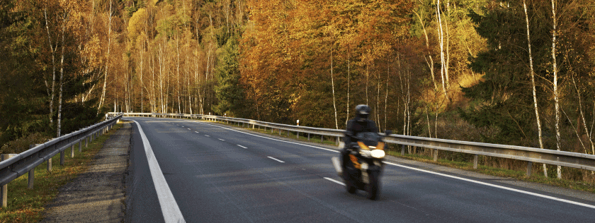 Biker riding motorbike in Autumn