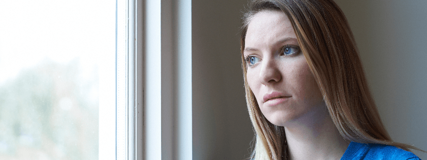 Woman looking sad at window