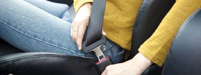 Woman putting on seatbelt