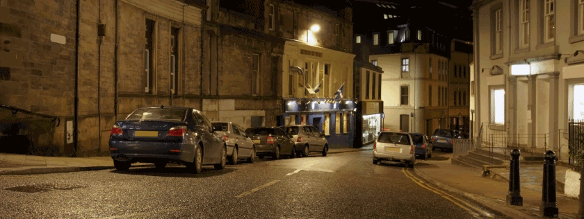 parked cars in the road at night