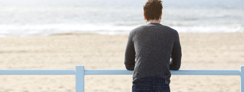 Man standing and looking out to sea