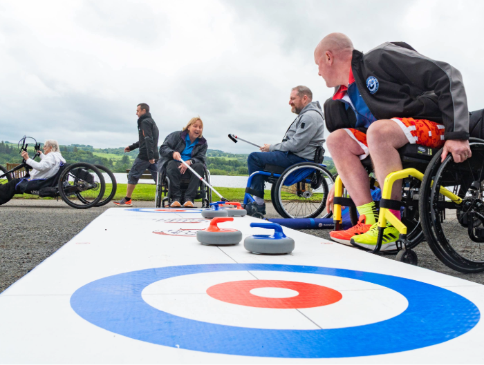 Wheelchair users participating in curling and handbiking