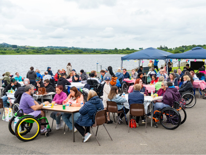 A large group of people chatting and mingling at the 2025 Spinal Injuries Scotland Summer BBQ and Activities Day