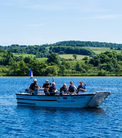 A group of people pictured on an accessible boat out on the water at Castle Semple