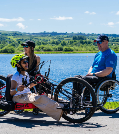 A female wheelchair user pictured using a handcycle