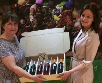 Inverness solicitors holding crate of wine from WoodWinters as one of the prizes at the charity race night