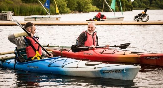 People with spinal injuries in adapted canoes on the water at Castle Semple