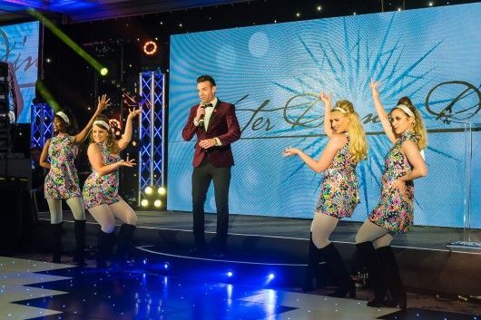 Des Clarke with dancers on stage at the Digby Brown Winter Dinner Dance 2019