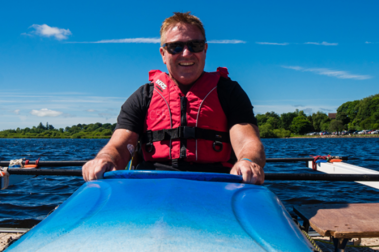 A male wheelchair user pictures in an adaptable kayak 