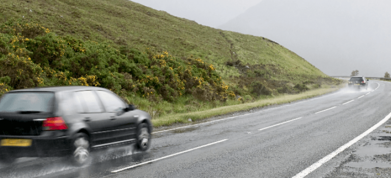 Car driving in the rain on country road